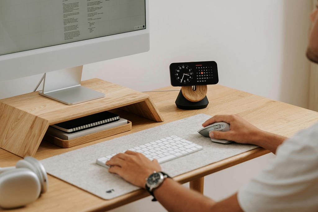 Blog A clean and modern desk setup featuring a computer, clock, and accessories in a home office.