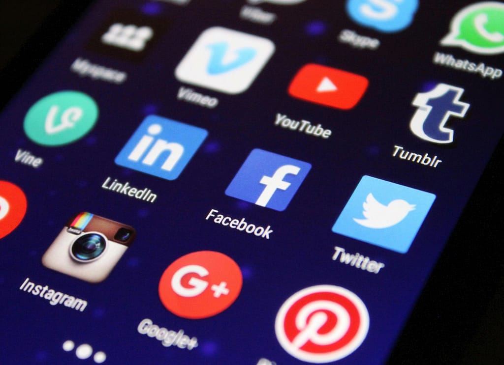 Blog Close-up of a smartphone screen showing various social media app icons such as Facebook and Twitter.