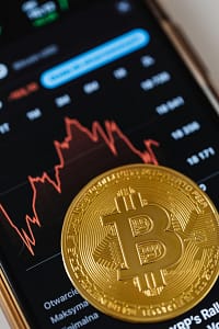 pexels photo 5980863 5980863 Gold Bitcoin coin on a smartphone showing financial graph, symbolizing digital currency and blockchain trends.